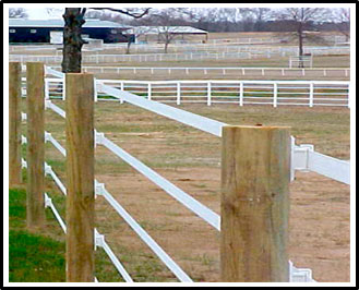 Photo d'un enclos à chevaux entouré d'une clôture électrique à cinq brins. Les brins sont attachés à de grands poteaux en bois à l'aide d'isolants électriques afin d'éviter la mise à la terre.