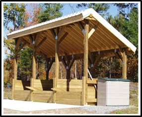 A picture of a covered compost station on a cement pad with multiple large composting bins.