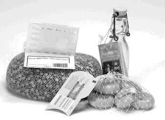 Les bouteilles d'huile décoratives, les petits fromages enrobés de cire dans un sac-filet et les sacs-filets d'oeufs de Pâques en chocolat emballés dans du papier d'aluminium.
