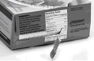 A tear strip runs across a nutrition facts table on the side of a box of frozen food, making the NFT partly unreadable.